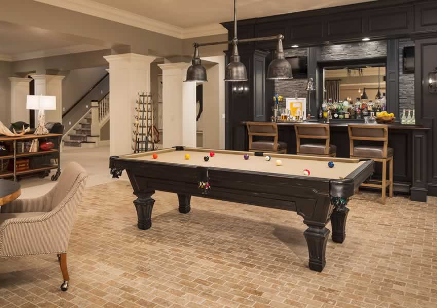 a basement living / gamesroom with staircase to upper floor and a bar area