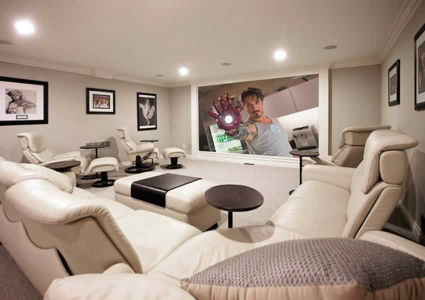 a well-lit basement tv room with large cinema / home theatre style TV