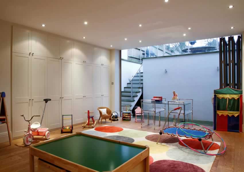 kids basement playroom with full height folding glazed doors to a sunken garden patio
